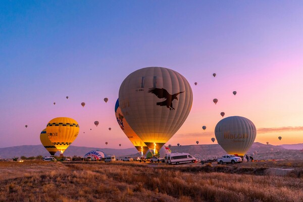 Hot air balloons rising as the sun rises
